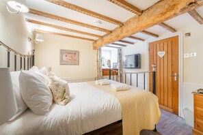 A hotel room with a bed, a television, a wooden door labeled 'Bathroom,' and a window with curtains. - 3 Bed in Windermere (oc-lr164) (Windermere)