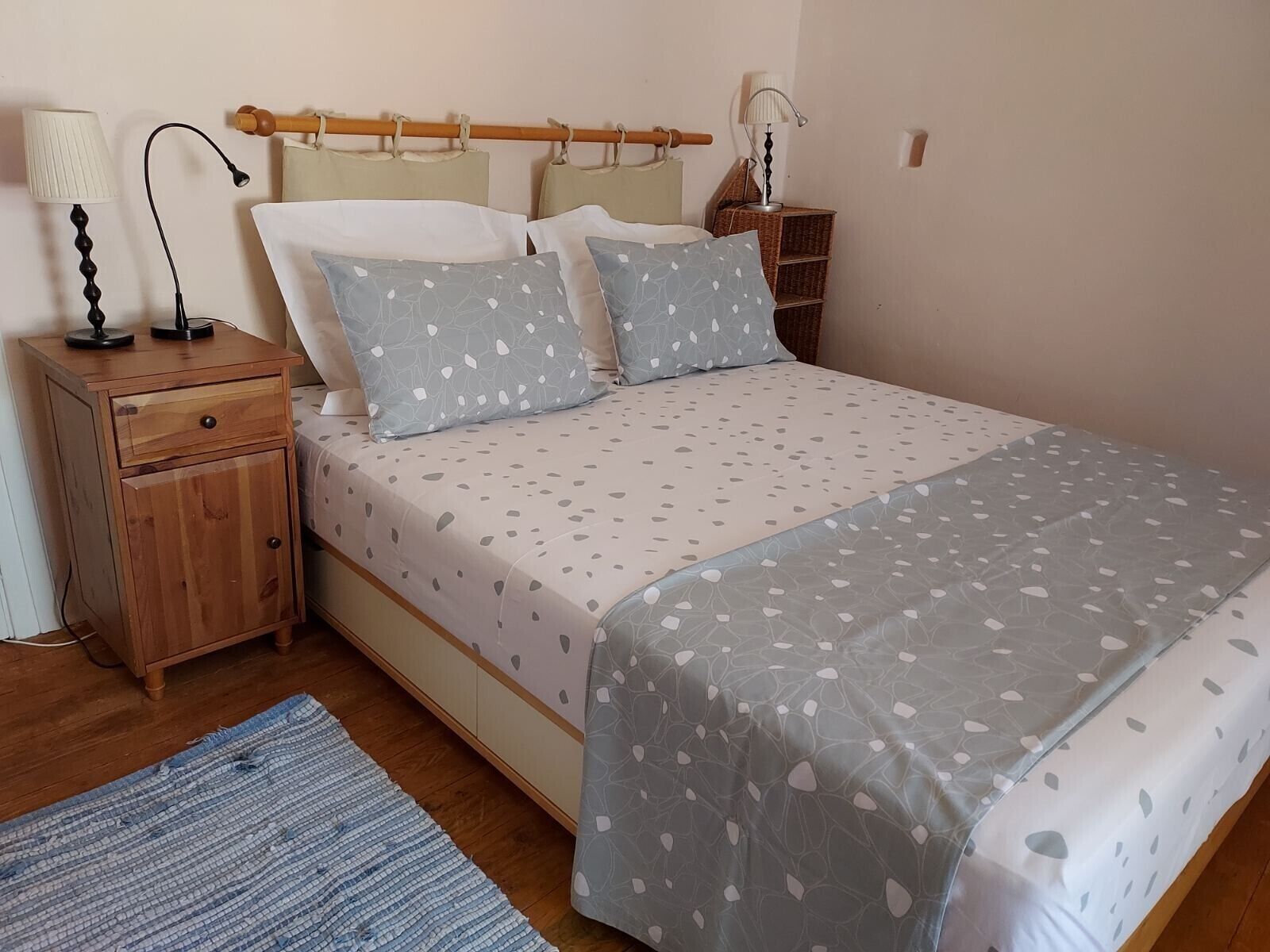 Ein Schlafzimmer mit einem Bett, Nachttischen, einer Lampe und einem Teppich.