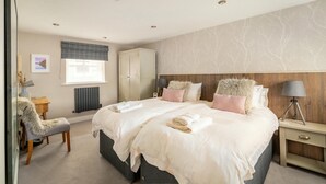 Une chambre à coucher comprenant un lit, une table de chevet, une lampe, une armoire et une chaise.