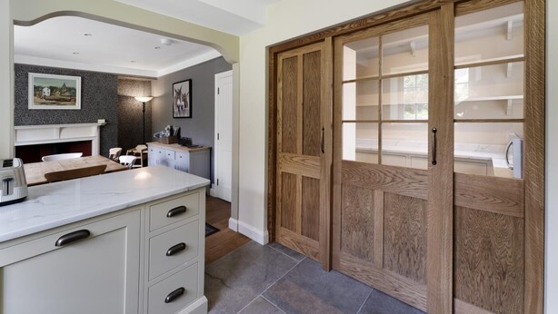 A modern kitchen with a marble countertop, wooden cabinets, and a built-in oven. - 3 Bed in Ambleside (oc-lr042) (Ambleside)