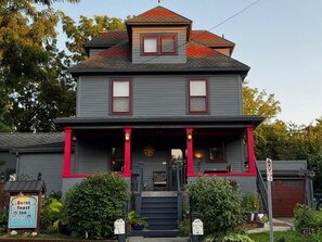A two-story building with a porch, a sign for 'Burnt Toast Inn,' and a mailbox. - Burnt Toast Inn and Washington House (Ann Arbor)