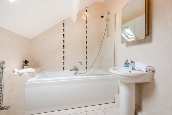 Een moderne badkamer met een bad, een wastafel en een douche.