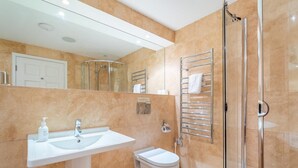 Ein modernes Badezimmer mit Waschbecken, Toilette und einer Duschkabine.