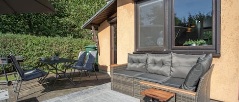 An outdoor seating area with a sofa, chairs, and a table.