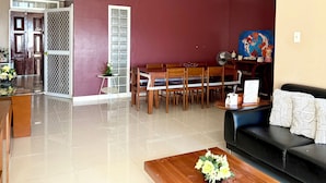 A living room with a dining area, a black sofa, a wooden coffee table, and a painting on the wall. - 2-bedroom condo unit in Cebu City (Cebu City)
