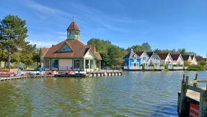 A lakeside building with a dock, boats, and a pier. - Belle Dune Apartment: Between the Lake, the Sea, and the Pine Forest (Fort Mahon)