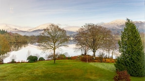 A tranquil lakeside landscape with a clear view of a mountain range in the distance. - 2 Bed in Ambleside (oc-lr211) (Claife)