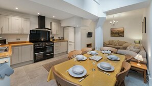 Una cocina moderna con comedor, un sofá y un televisor.