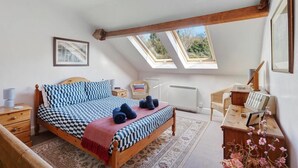 A bedroom with a checkered bedspread, a wooden desk, a chair, a radiator, and skylights. - 3 Bed in Grasmere (oc-lr193) (Grasmere)