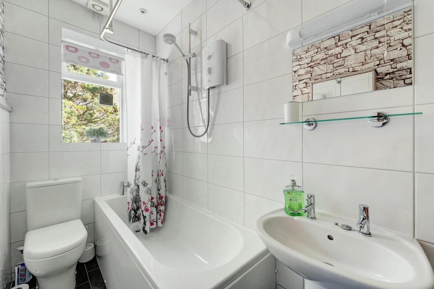 Een moderne badkamer met een bad, toilet en wastafel.