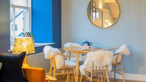 A cozy room with a round table, chairs, a lamp, and a mirror. - 1 Bed in Bowness (oc-lr150) (Bowness on Windermere)