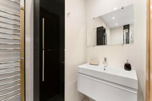 A modern bathroom with a white vanity, a large mirror, and a black door. - 2 Bed in Ambleside (oc-lr191) (Ambleside)