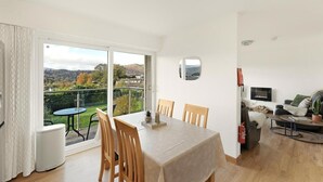 A dining area with a table and chairs, a view of the outdoors, a sofa, and a television. - 2 Bed in Ambleside (oc-lr191) (Ambleside)