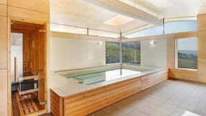 A modern spa room with a wooden bath, large windows, and a view of a mountainous landscape. - 1 Bed in Ambleside (oc-lr175) (Ambleside)