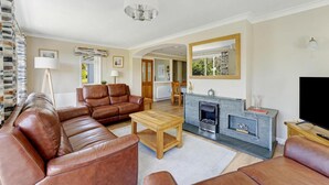 A living room with a sofa set, a coffee table, a fireplace, and a television. - 4 Bed in Ambleside (oc-lr120) (Ambleside)