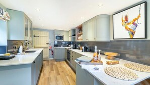 Une cuisine moderne avec des meubles gris, un four à micro-ondes et un grand îlot central doté d’un évier.