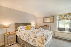 A bedroom with a bed, bedside table, lamp, dresser, mirror, and window with a view. - 2 Bed in Ambleside (oc-lr074) (Skelwith)
