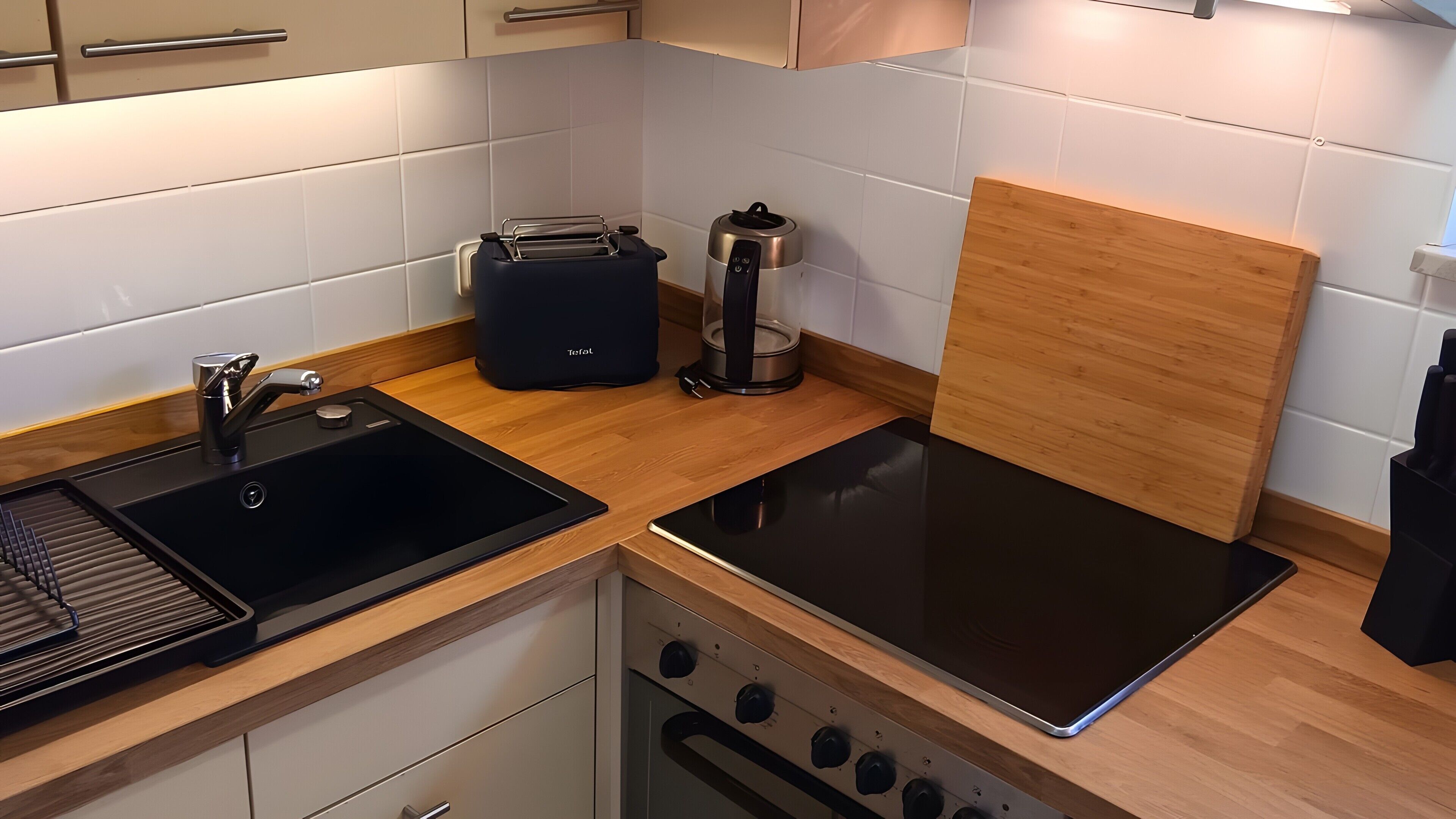 Eine moderne Küche mit Spüle, Toaster, Wasserkocher und Backofen.