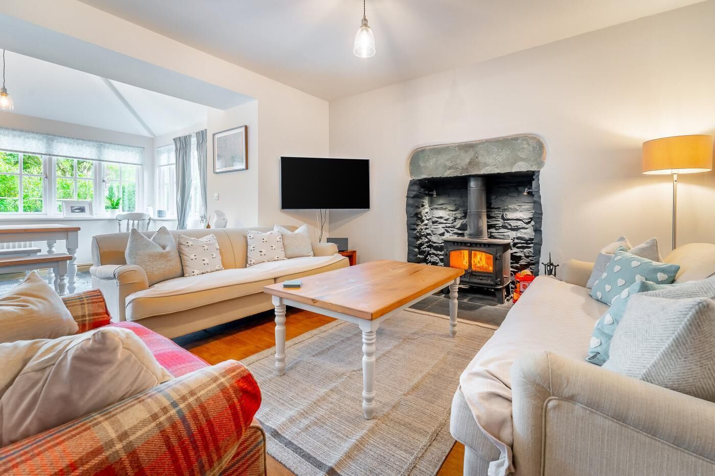 A cozy living room with a fireplace, a sofa, a TV, and a table.