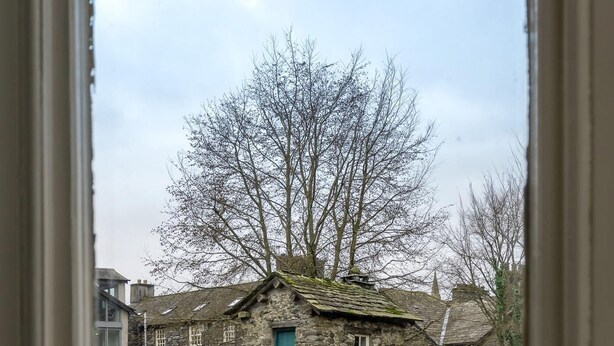 A stone building with a pub sign, a stone wall, and a road in front. - 4 Bed in Ambleside (oc-lr034) (Ambleside)