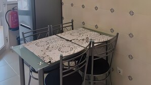 A dining area with a table and chairs, a clock on the wall, and a refrigerator. - Apartment 'Casa Várzea' with Wi-Fi (Lagos)