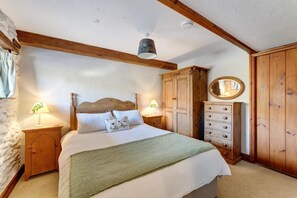 A bedroom with a wooden bed, two bedside tables with lamps, a wardrobe, and a mirror. - 2 Bed in Ambleside (oc-lr177) (Ambleside)