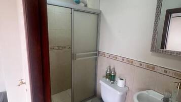 Ein Badezimmer mit Toilette, Waschbecken und Dusche.