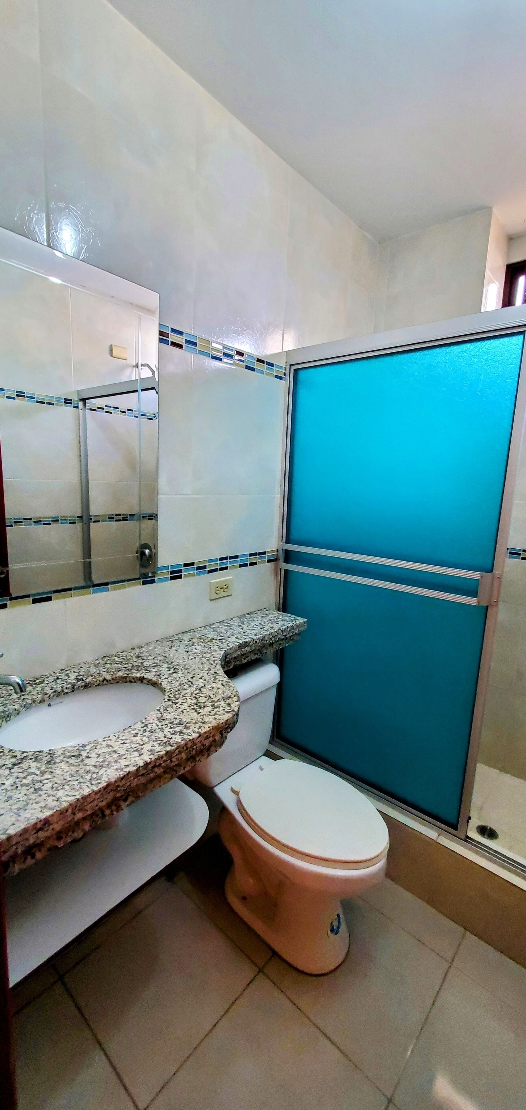 Un baño con lavamanos, inodoro y cabina de ducha.