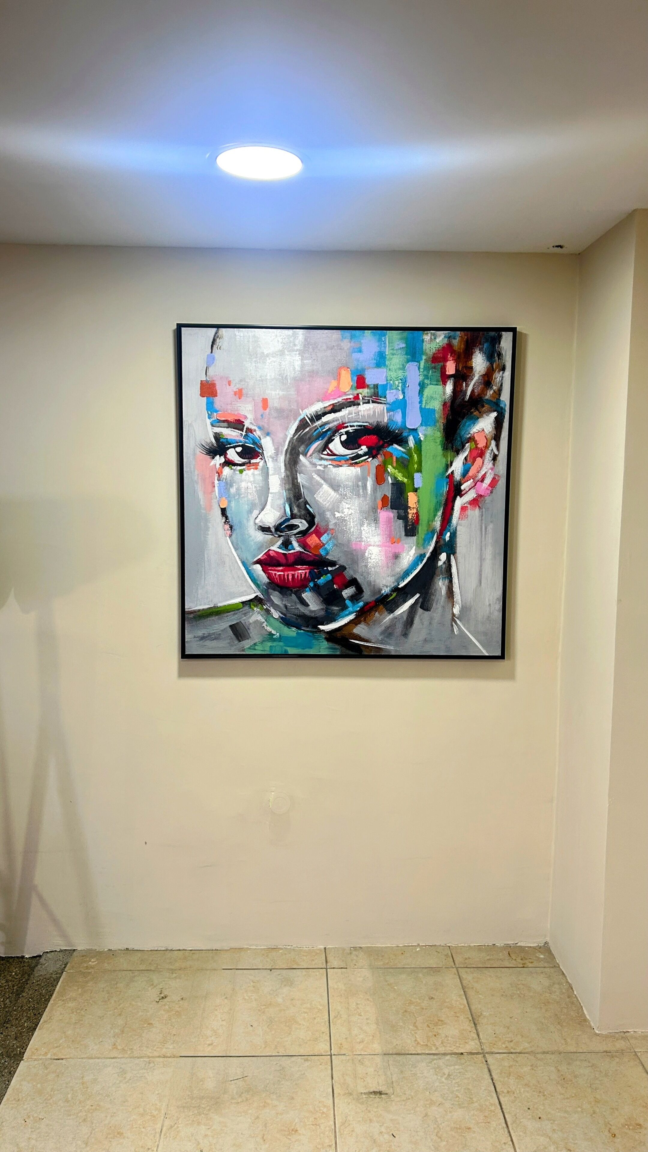 A painting on a wall in a hallway with a tiled floor.