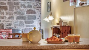 Een aanrecht met een theepot, croissants en glazen sinaasappelsap.