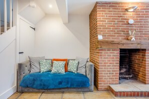 A cozy living room with a sofa, pillows, and a fireplace. - 4 Bed in Lymington (oc-c41423) (Lymington)