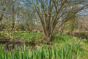 A natural landscape with a pond, trees, and a picnic table. - 2 Bed in Westfield (oc-b40267) (Sedlescombe)