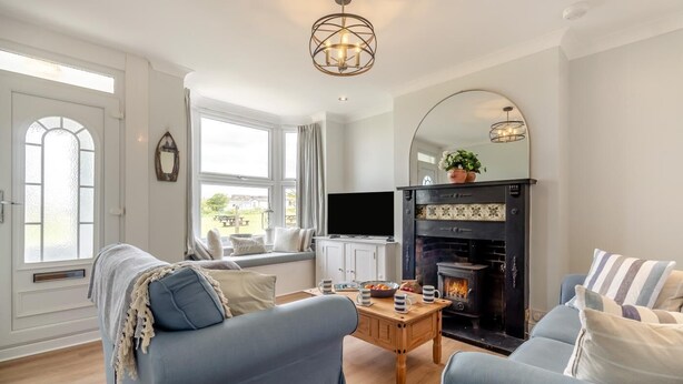 Una sala de estar con chimenea, televisión y sofá.