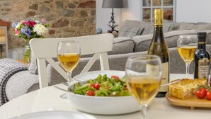 A dining table with a salad, two glasses of white wine, a bottle of wine, and a slice of pizza. - 2 Bed in Easington (oc-coq114) (Easington)