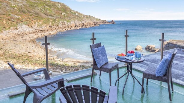 A terrace with a view of the sea, outdoor seating, and a table with a drink and snacks. - 1 Bed in Lamorna Cove, (oc-h40239) (Lamorna)