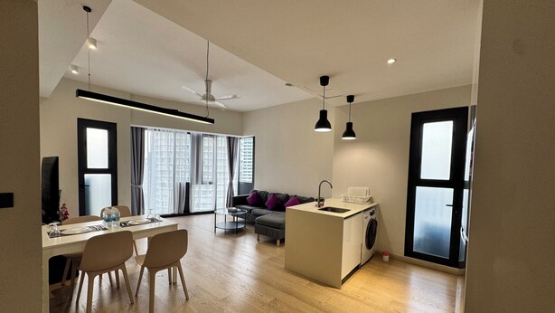 A modern apartment with a dining area, a sofa, a washing machine, and a ceiling fan. - Star Residence Klcc By JR Kuala Lumpur (Kuala Lumpur)