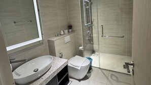 A modern bathroom with a large mirror, two sinks, a toilet, and a glass-enclosed shower. - Star Residence Klcc By JR Kuala Lumpur (Kuala Lumpur)