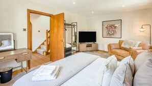 A hotel room with a bed, a TV, a sofa, a desk, and a bathroom. - 3 Bed in Pitlochry (oc-t37864) (Pitlochry)
