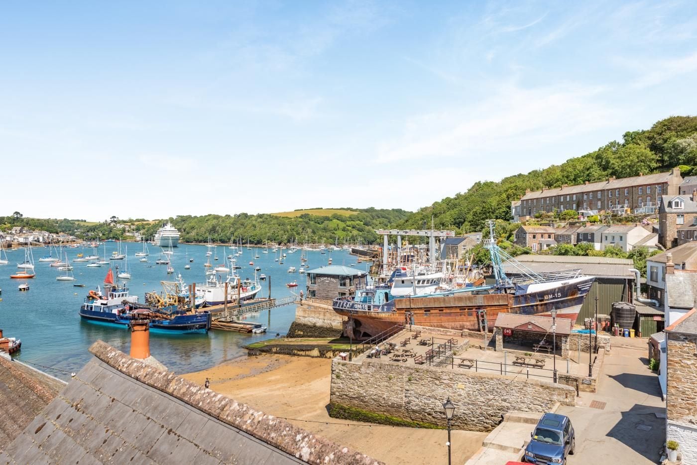 A harbor with boats, a dock, and buildings in the background.