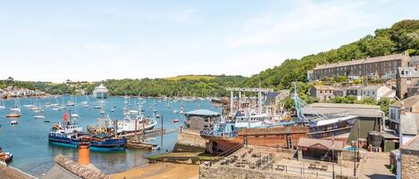 A harbor with boats, a dock, and buildings in the background.