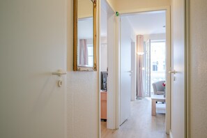 A hallway leading to a room with a door, a mirror, a desk, and a chair. - Ferienwohnung im 2.og mit Balkon in Sellin (Sellin)