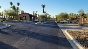 A paved road leading to a stone building with a red roof, palm trees, and a sign indicating a medical center. - Peaceful and quiet 1-bedroom condo with AC in charming Borrego Springs (Borrego Springs)