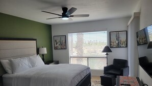 A bedroom with a bed, a desk, a chair, a ceiling fan, and artwork on the walls. - Peaceful and quiet 1-bedroom condo with AC in charming Borrego Springs (Borrego Springs)
