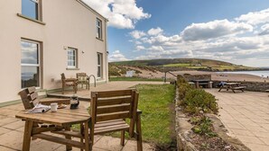 A building with a patio area, a wooden table, and benches. - 2 Bed in Braunton (oc-87111) (Croyde)