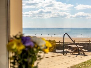A beach view with a wooden bench and a picnic table. - 3 Bed in Braunton (oc-87108) (Croyde)