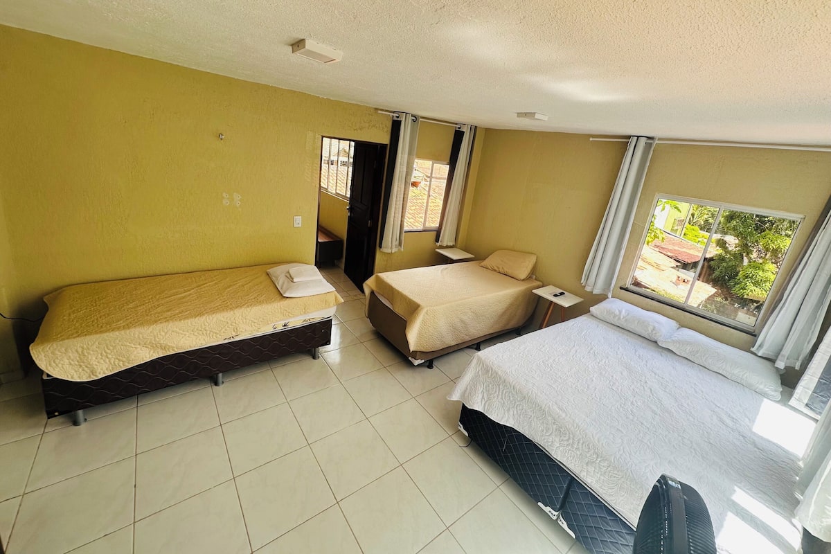 A hotel room with two beds, a television, and a window with a view.