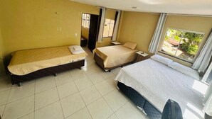 Una habitación con dos camas, una ventana y una puerta.
