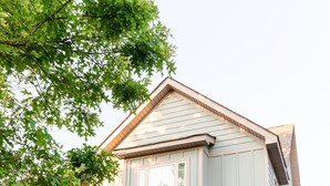 Et toetagers hus med en veranda, garage og en velplejet græsplæne.