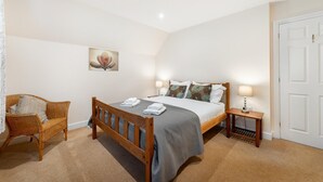 A bedroom with a wooden bed, a chair, a bedside table, and a door. - 1 Bed in Skelwith Bridge (oc-lr159) (Skelwith)