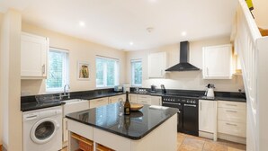 A modern kitchen with a central island, built-in appliances, and ample counter space. - 1 Bed in Skelwith Bridge (oc-lr159) (Skelwith)